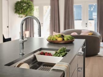 A sleek, modern sink is built into the spacious kitchen island, creating room to wash and clean vegetables while visiting with guests.