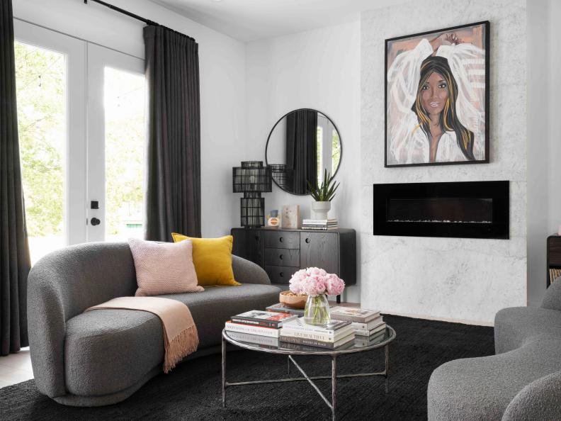 The curves of the two kidney-shaped sofas, round coffee table, and round mirrors that flank the fireplace add softness to this luxe entertaining space.