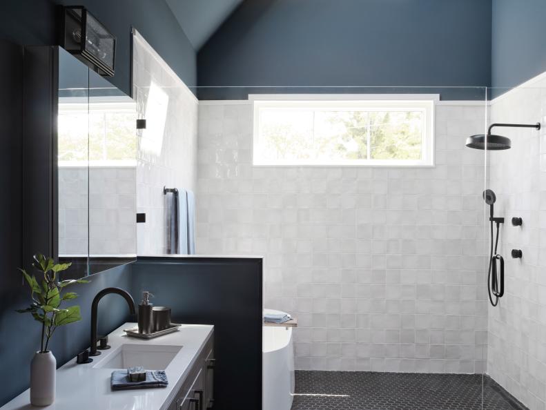 A strong horizontal window in the shower brings light into the space while still maintaining privacy. A glass partition keeps the shower space feeling open while white porcelain tile in a marble finish adds stylish luxury to morning showers.