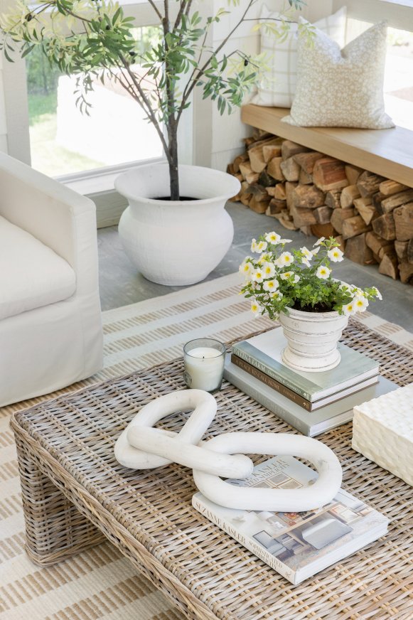 Woven coffee table with white chain links and flowers.