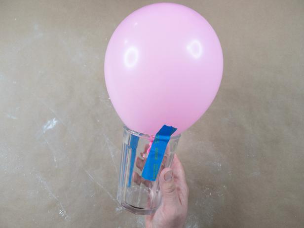 Pink balloon taped to a drinking glass