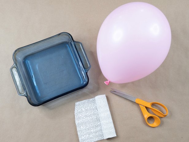 A glass baking tray, balloon, scissor and plaster strips 