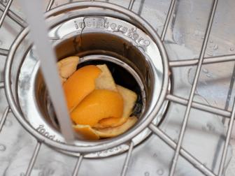 Orange peels placed in a sink drain to clean a garbage disposal.