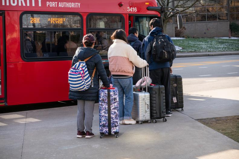 People wait to board an airport bus.