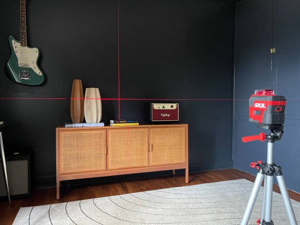 To hang a gallery wall using a laser level, set the laser level to project on the wall and align the beams with your desired layout.