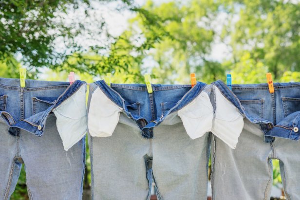 The washed jeans hang on a clothesline. Pockets turned inside out. Drying clothes on the street. Life style.