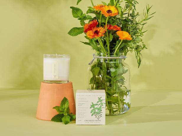 mint candle next to bouquet of mint and wildflowers