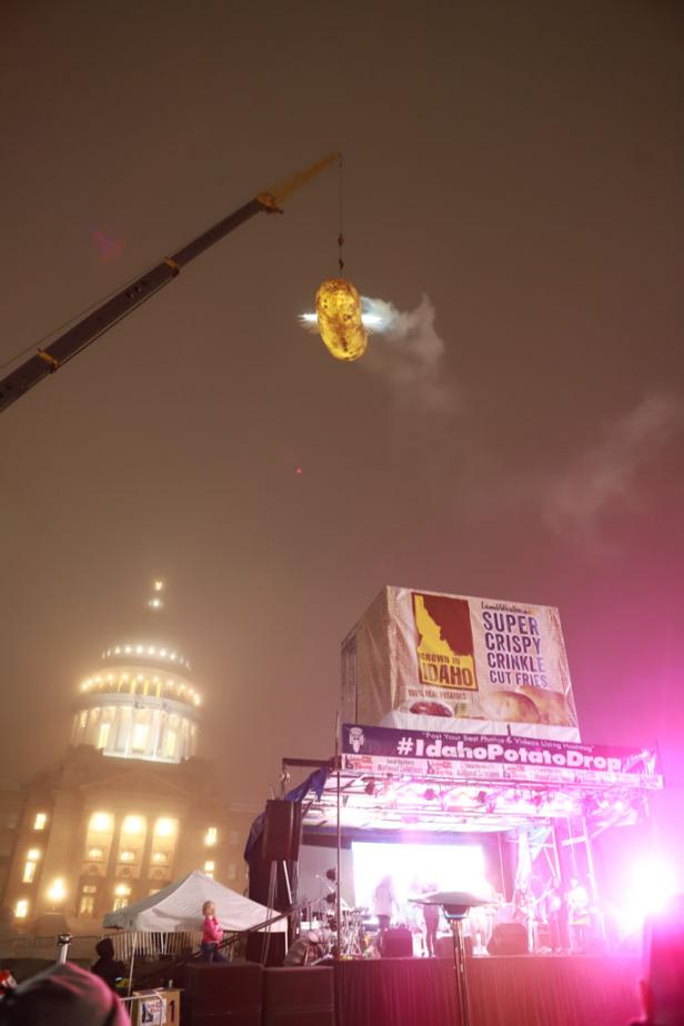 A crowd watches from below as the Boise, Idaho "GlowTato," a giant, illuminated potato, drops from a crane at midnight on New Year's Eve.
