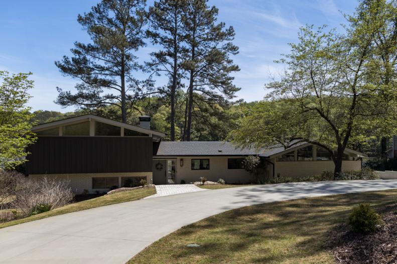 Split-level home with white brick and grey board-and-batten exterior.