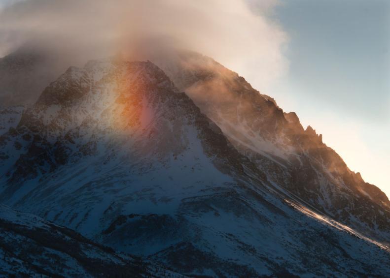 A sundog, an atmospheric nature event, illuminating the mountains in Alaska's Denali National Park
