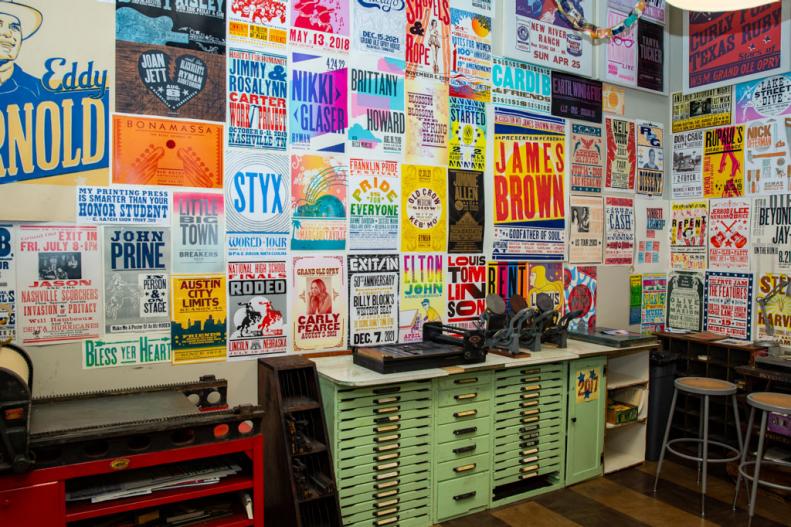 Differently-sized letterpress entertainment posters on a wall. 
