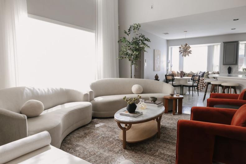 An image of a modern, open concept living room with cream couches.