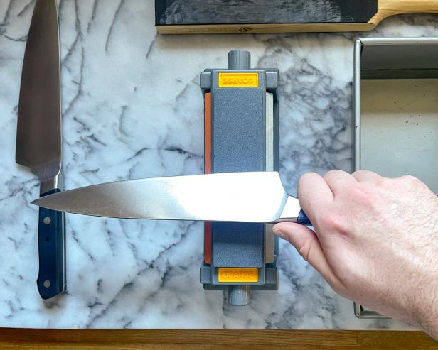 The next step in sharpening a knife using a sharpening stone is to hold the knife at a 22.5-degree angle before finding the final angle.
