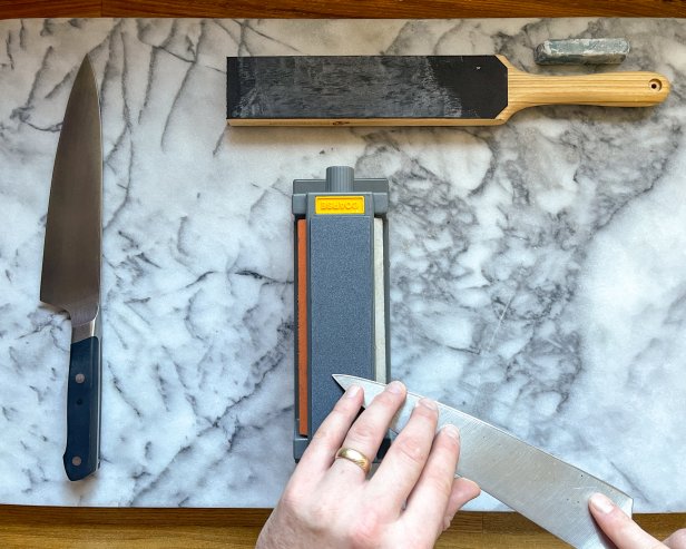 The next step in sharpening a knife using a sharpening stone is to move carefully to the tip of the knife to form a burr along the entire edge.
