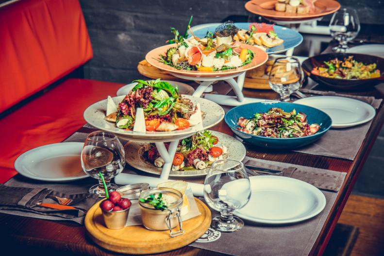 Many different dishes on a tiered serving stand on a restaurant table