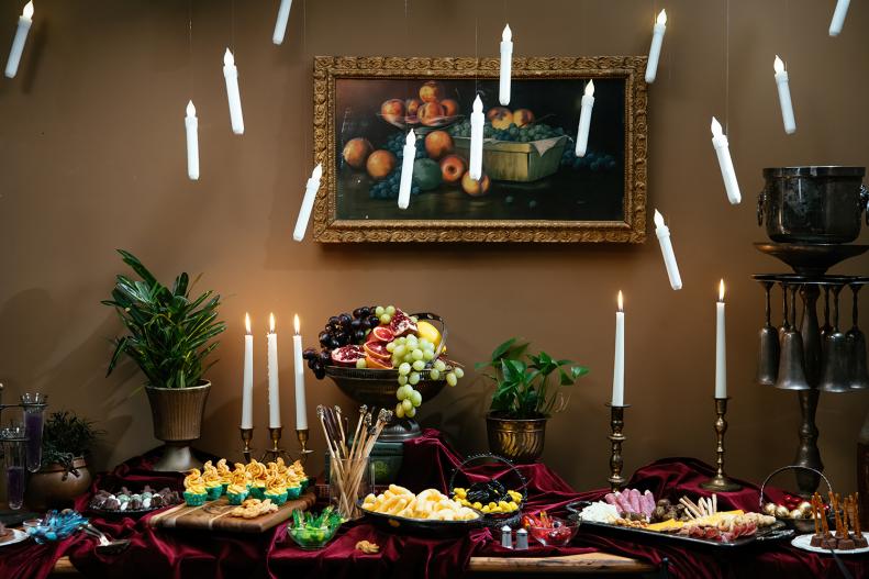 Buffet Table of Wizard Food With Candles Floating Above 
