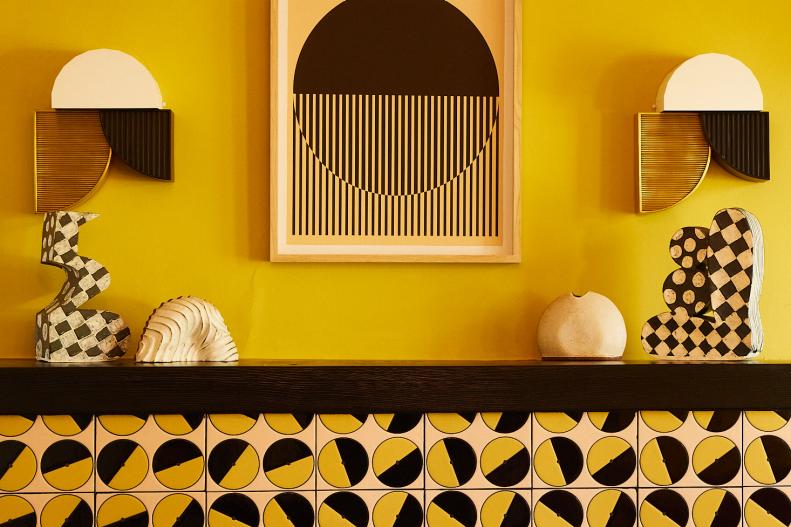 Yellow walls in living room circular black tiles on fireplace mantel