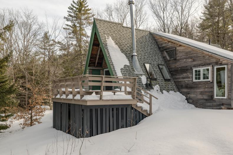 An A-frame cabin in New Hampshire covered in snow 