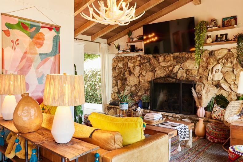 White living room with large stone hearth and antler chandelier. 