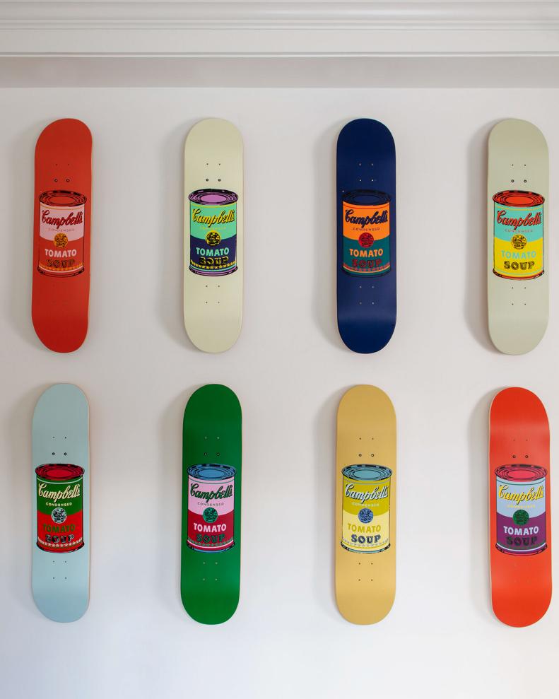 Eight Campbell's Soup Can skateboard decks mounted on a wall. 
