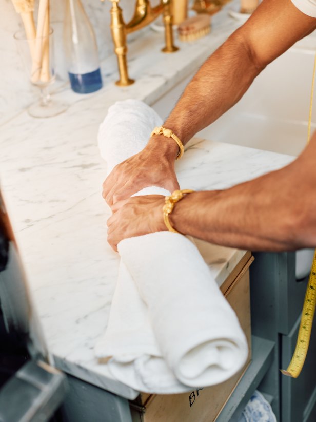 A Man Squeezing a Rolled Towel