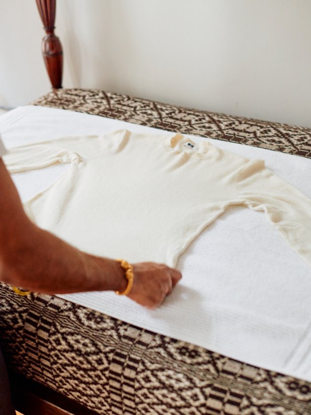 A Man Laying a Wool Sweater on a Towel