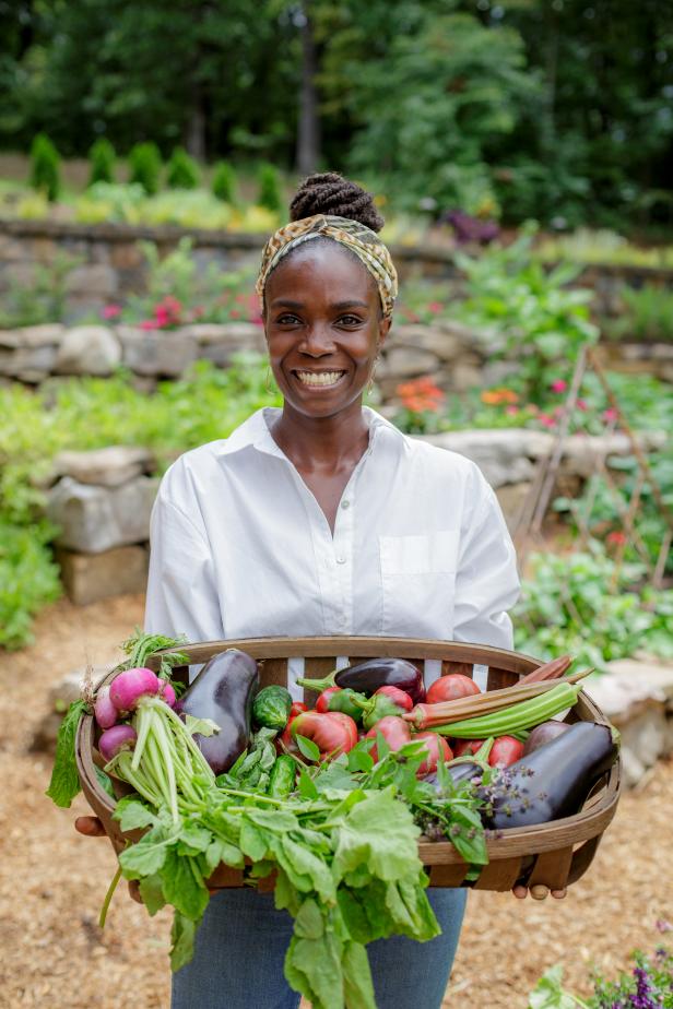Host Jamila Norman poses with vegetables harvested from the Abbott's new garden, as seen on "Homegrown."
