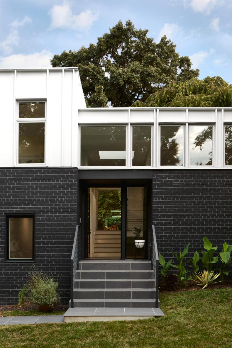 This house features a black-and-white exterior and glass doors.