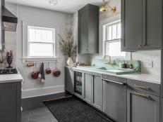 Farrow & Ball Green Smoke paint color paired with brass accents and a white Corian countertop gives this kitchen a timeless-meets-trending look.