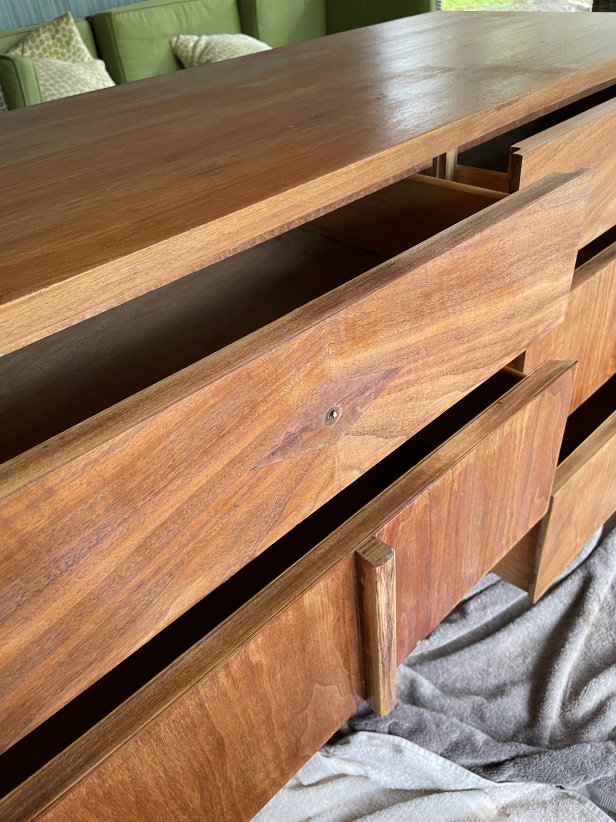 A wooden sideboard being sealed with spar urethane.