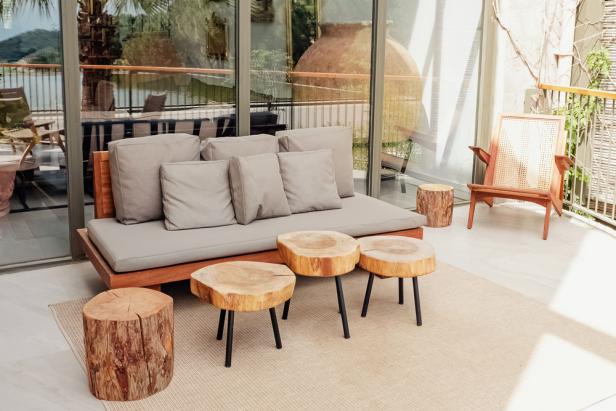 Wooden sofa and coffee tables on cozy stylish modern terrace, patio, backyard. Natural eco materials