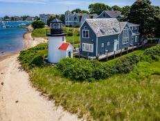 Blue Cape Cod House With White Lighthouse