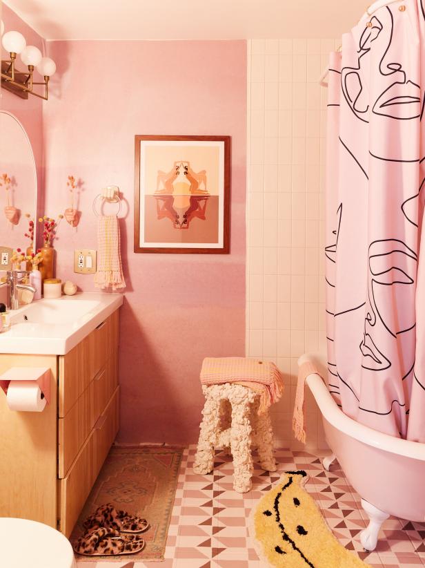 Pink bathroom with graphic floor, mural wallpaper and foam stool.