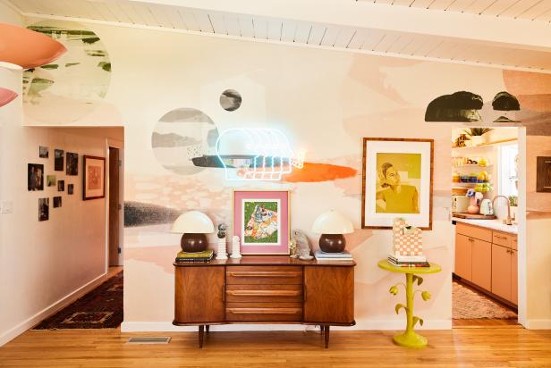 White living room with wood credenza, neon wall art, and accessories.