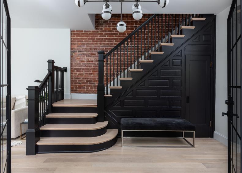 Glossy Black Stairs Against a Brick Wall