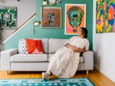 Rachel Gloria Adams Sits on Sofa in Front of Bright Prints