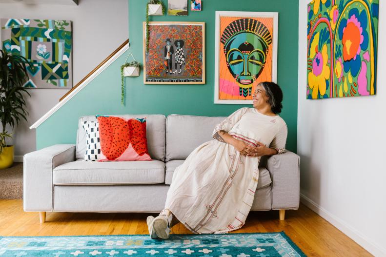 Rachel Gloria Adams With Bright Art on a Green Wall in the Living Room