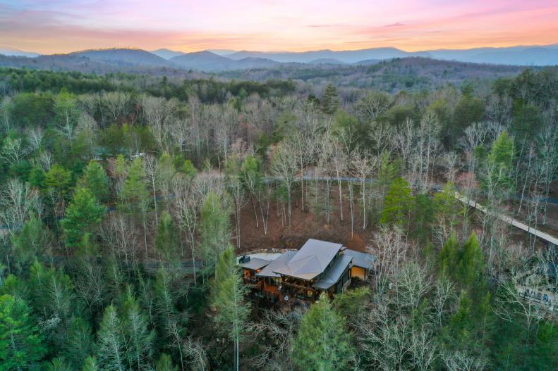 Aerial view of big rustic mansion tucked between Blue Ridge Mountains