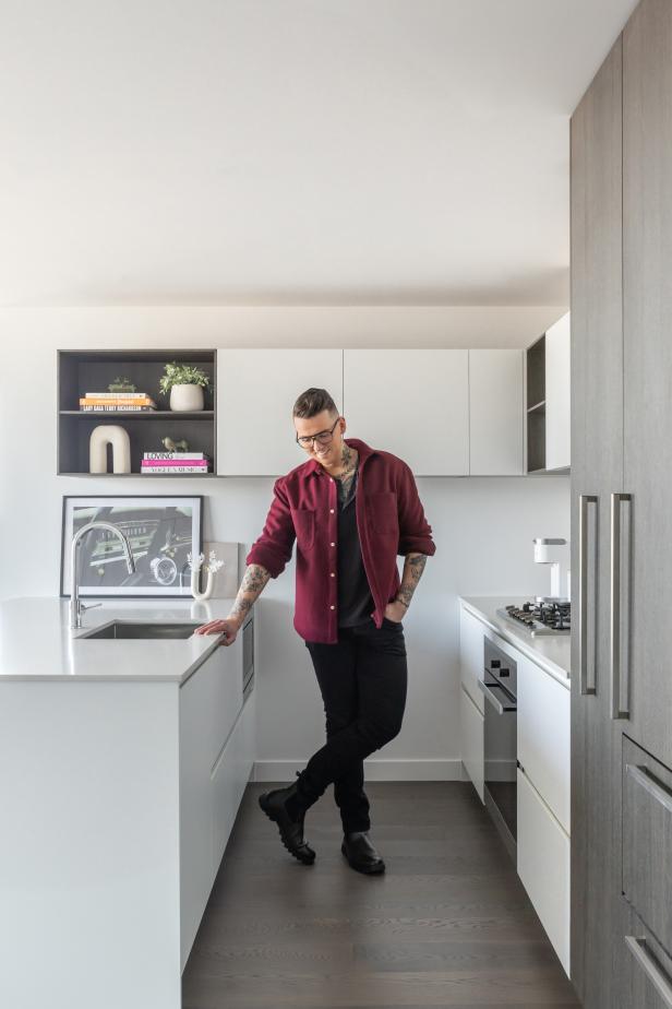 Man Standing in Galley-Shaped Kitchen With Hand in Pocket