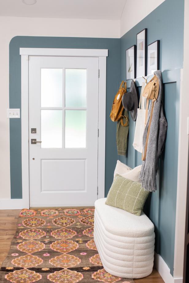 An Entryway With a Blue Accent Wall and Patterned Rug