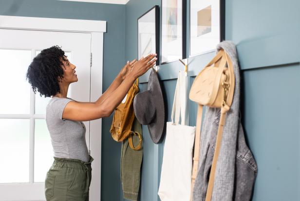 The next step in this DIY accent wall project is to hang art above the coat hooks and display cute coats and bags on the hooks.