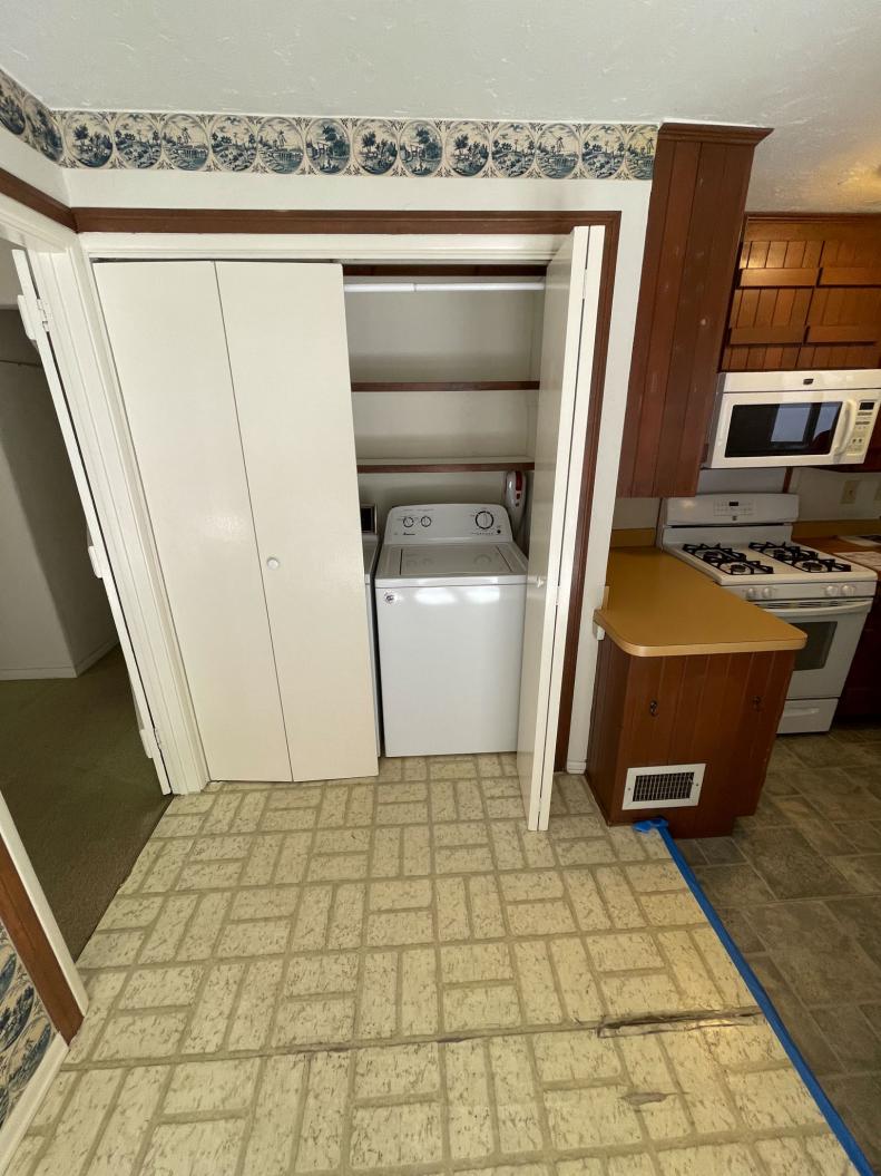 A washing machine inside closet with accordion doors