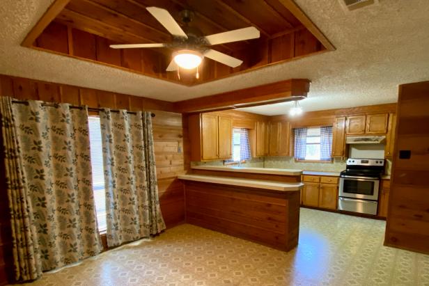 The retro kitchen was preserved in time with matching wood paneling and cabinets as well as beige linoleum flooring.