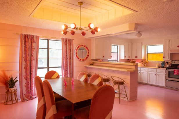 Dining Table With Chandelier and Galley Kitchen in the Background