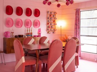 Dining Table With Six Chairs and Eight Cowboy Hats Hung on the Wall Behind