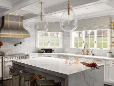 White Kitchen With Large Island Countertop and Bar With Three Stools 
