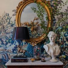 Ornate Mirror Above Side Table with Cloche Decor, Grecian Bust, and Pegasus Lamp