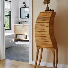 Curved Wooden Cabinet In a Hallway Outside a Bathroom