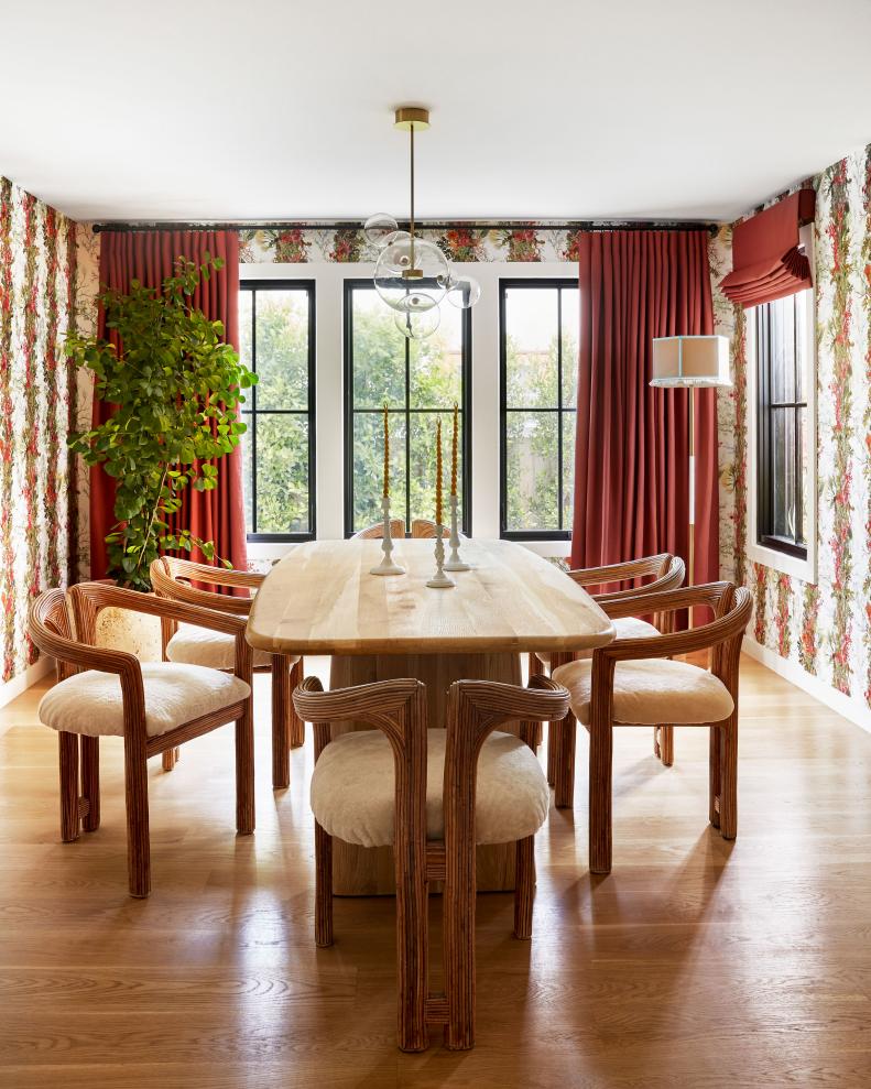 Formal dining room with striped floral wallpaper and red curtains.