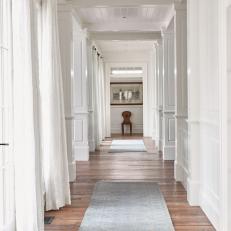 Hardwood Floor Adds Warmth to Long White Hallway